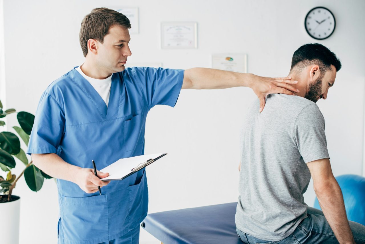 chiropractor-with-diagnosis-and-pen-massaging-neck-of-man-in-hospital.jpg